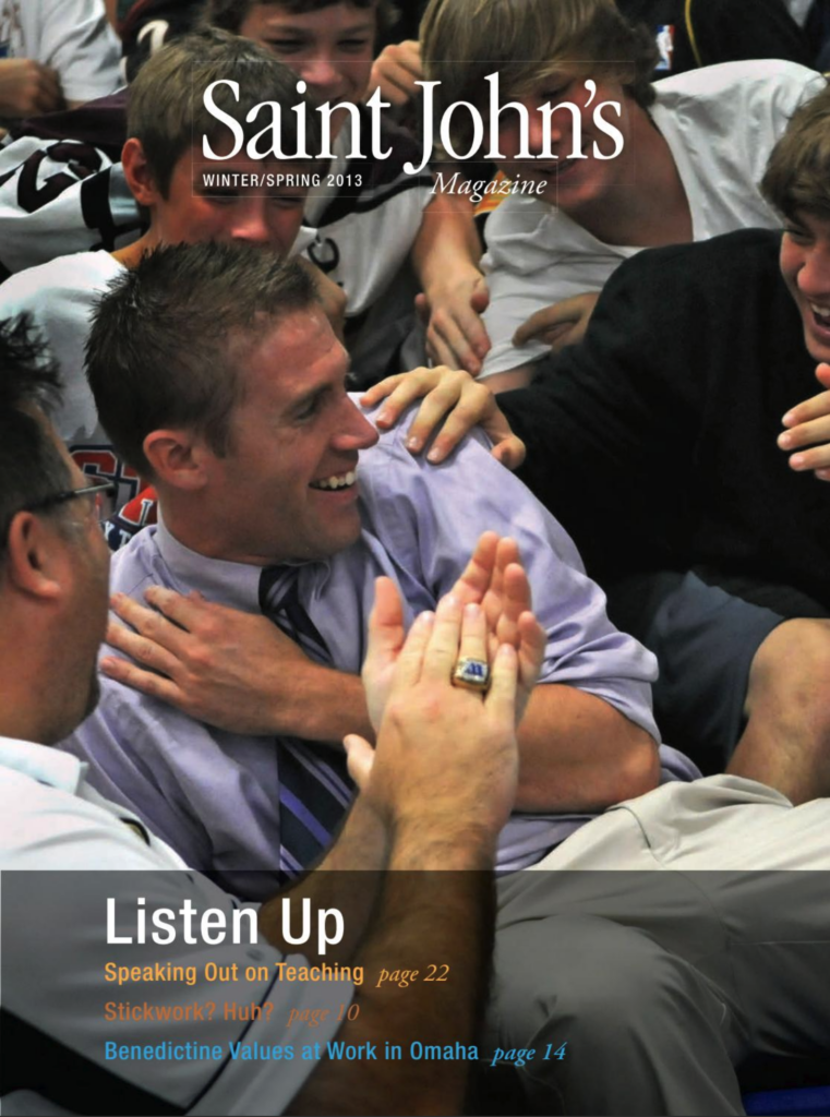 A group of people, including a man in a shirt and tie, sit closely together, smiling and engaging in conversation. The man is at the center, appearing enthusiastic. The cover reads "Saint John's Magazine Winter/Spring 2013" with article titles featured below.